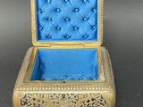 an ornate gold and blue box with a blue velvet lining