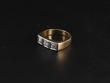 gros plan d'une bague en or et diamants sur une surface noire