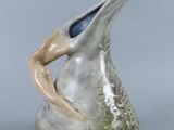 a silver vase that has a bird on it ' s head