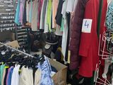 une pièce remplie de nombreux vêtements et d'un portant à vêtements