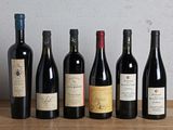six bouteilles de vin sont alignées sur une table en bois