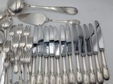 a lot of silverware on a table with spoons and knives