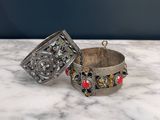 a close up of two silver bracelets on a marble surface