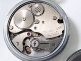 a close up of a pocket watch on a white surface