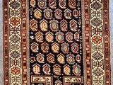 an antique persian rug with geometric design on a blue ground