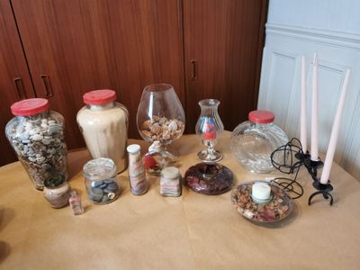 une table sur laquelle sont disposés de nombreux bocaux et des bougies