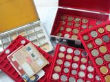 a lot of coins in a red case on a table