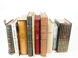 several books are stacked on top of each other on a white surface