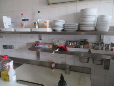 une cuisine où il y a beaucoup de vaisselle et de plats sur les étagères