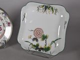 two plates with floral designs on them sitting next to each other
