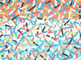 colorful confetti sprinkles are scattered on a white surface