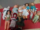 a lot of dolls that are laying on a red blanket