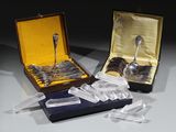 deux cuillères en argent et une cuillère en argent dans une boîte posée sur une table