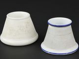 two white and blue vases sitting on a black surface