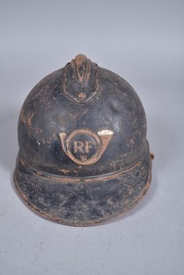 un vieux casque de pompier posé sur une surface blanche
