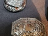 two silver buttons on a table with a black background