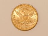 a close up of a gold coin on a white surface