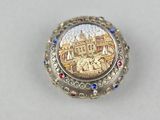 an image of a silver and gold broochle with a picture of a castle