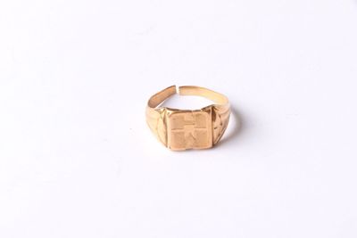 a close up of a gold ring on a white surface