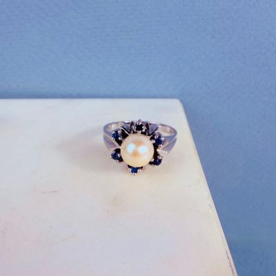 un gros plan d'une bague posée sur une table, sur fond bleu