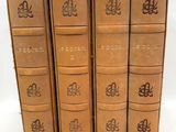 four old books are lined up in a row on a white surface