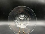 a clear glass with a metal stand on a table