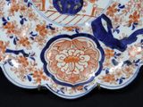 a blue and orange plate with birds and flowers on it