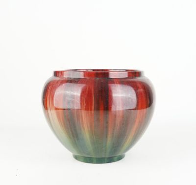 a close up of a red and green vase on a white background