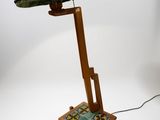 a lamp that is on a wooden stand with a green shade on it