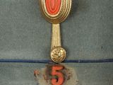 a green hat with a red badge on it