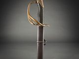 a close up of a sword with a gold handle on a black background