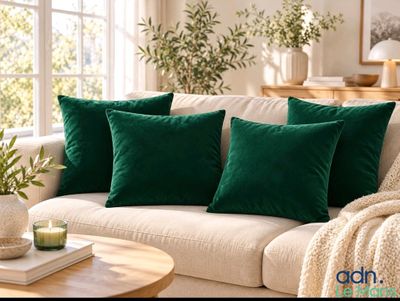 three green pillows on a white couch in a living room