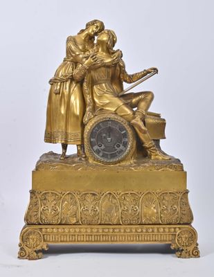 a gold clock with a man and a woman on it