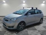 the small silver car is parked in a large room with a checkered floor
