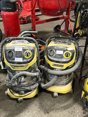 Plusieurs aspirateurs sont alignés les uns à côté des autres dans un garage