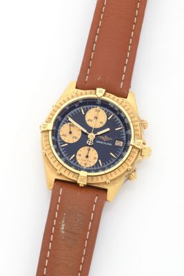 a close up of a watch on a white surface with a brown strap