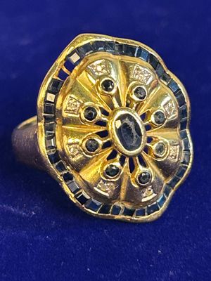an image of a gold ring with black and white stones