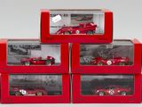 trois petites voitures rouges sont exposées dans une vitrine posée sur un socle blanc