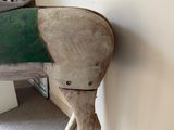 a wooden horse that is standing next to a wall