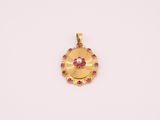 un pendentif en or orné de pierres roses sur fond blanc