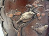 a vase with a bird and flowers on it