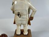 a small statue of a man with a bag and a shoe