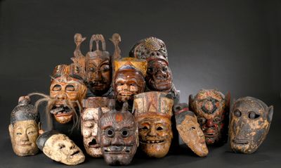 many wooden masks that are sitting on a black surface