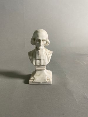 une petite statue représentant un homme assis sur une table
