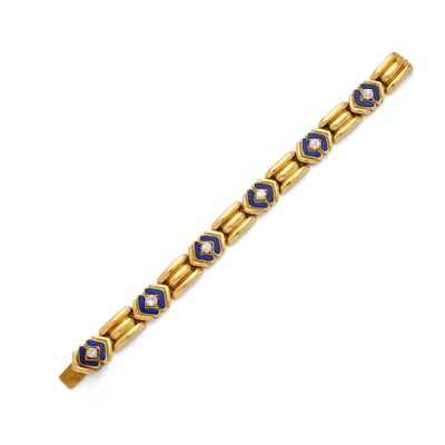 a gold bracelet with blue and white beads on a white background