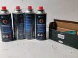 four canisters of paint sitting on a table next to a cardboard box