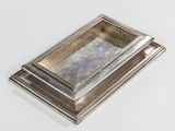 a silver tray with a mirror on it on a white surface