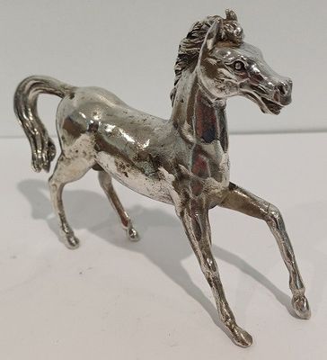 une figurine de cheval en argent posée sur une table