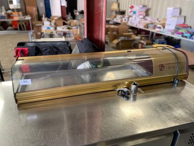 une table en métal sur laquelle est posée une vitrine en verre