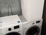 deux lave-linge et un sèche-linge dans une petite pièce